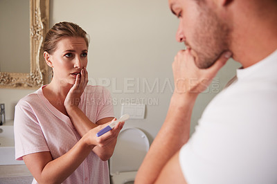 Buy stock photo Cropped shot of a wife showing her husband a pregnancy test in the bathroom at home