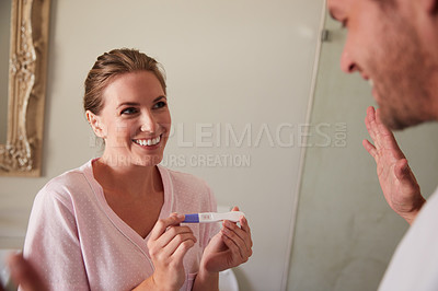 Buy stock photo Cropped shot of a wife showing her husband a pregnancy test in the bathroom at home