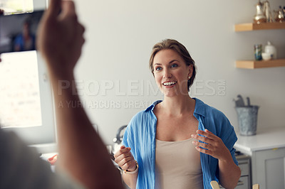 Buy stock photo Cropped shot of an unrecognizable man taking a picture of his wife while she is cooking in the kitchen at home