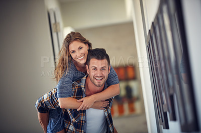 Buy stock photo Cropped shot of a young handsome man giving his beautiful wife a piggyback ride at home
