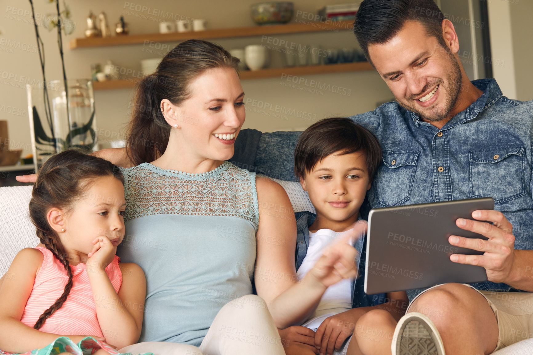 Buy stock photo Shot of a family of four sharing a digital tablet