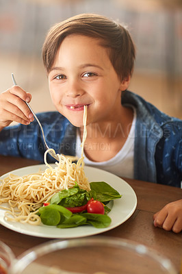 Buy stock photo Cropped shot of an adorable little boy eating his food at home