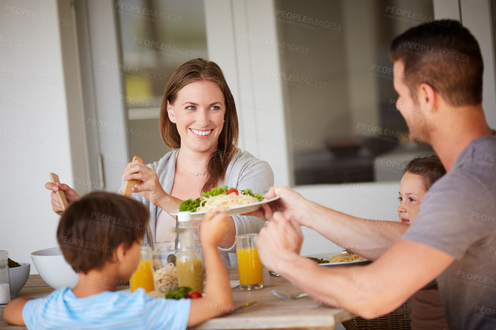 Buy stock photo Cropped shot of a family of four sitting down for a meal at home