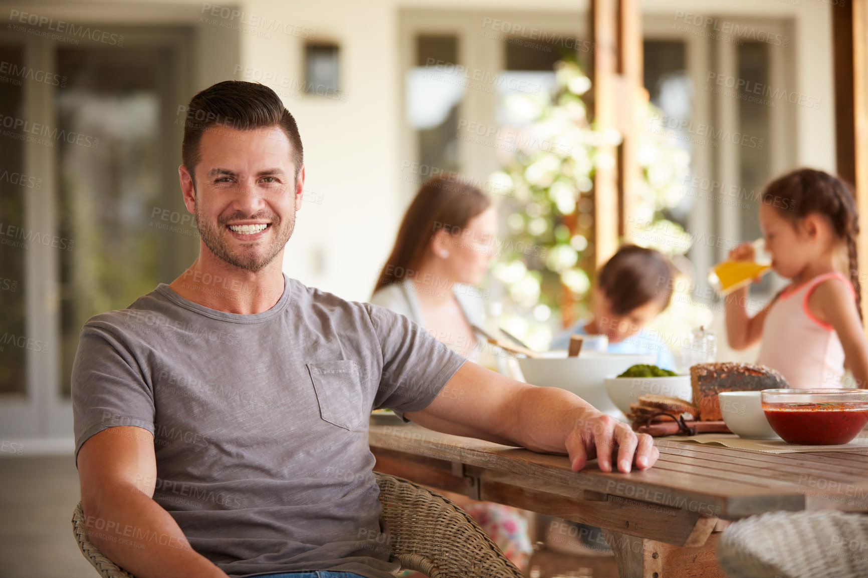 Buy stock photo Portrait of a man at home with his family sitting in the background