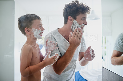 Buy stock photo Kid, father and learning to shave, laughing and bonding together in bathroom. Funny, dad and teaching child with shaving cream on face beard, playing or cleaning, hygiene or enjoying hair removal.