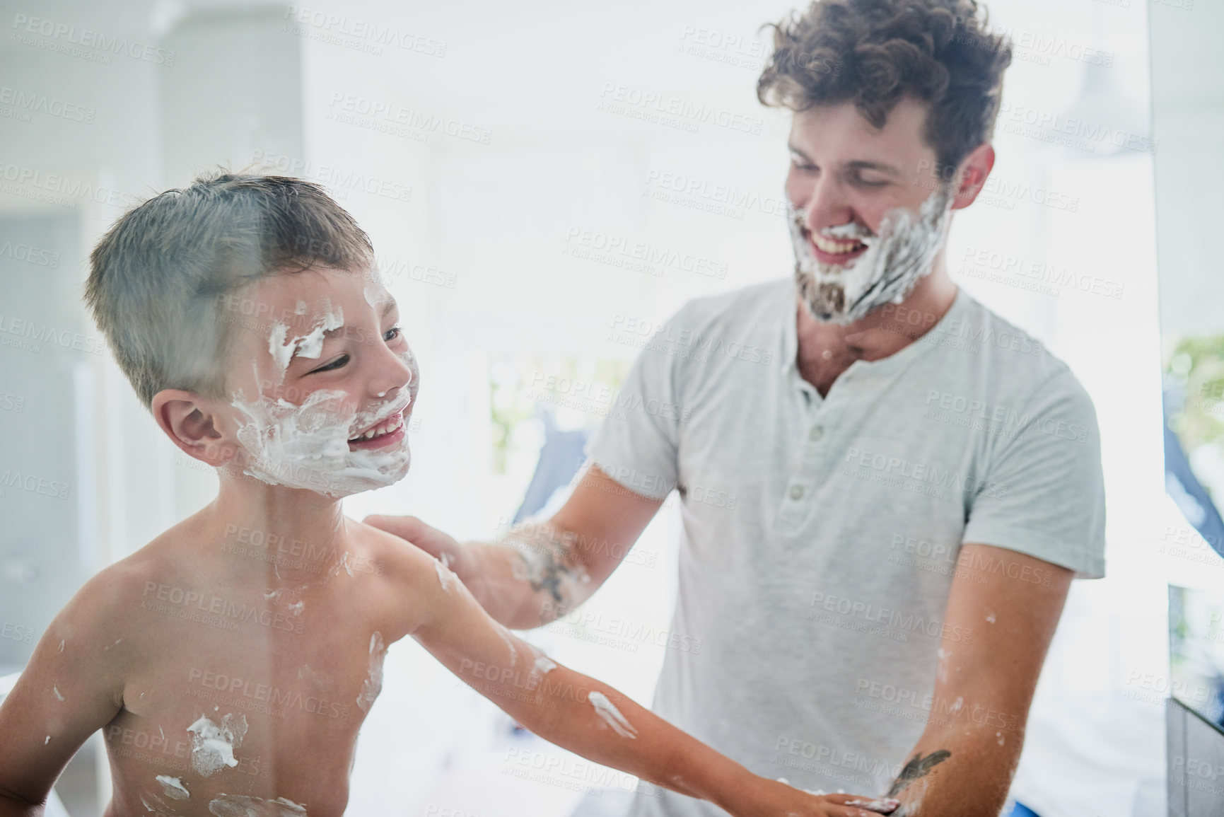 Buy stock photo Shot of a father teaching his little son how to shave in the bathroom at home