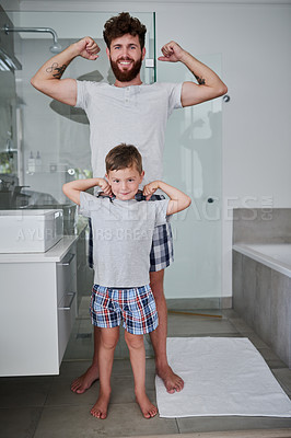 Buy stock photo Portrait of a father and his little son flexing their arms in the bathroom at home