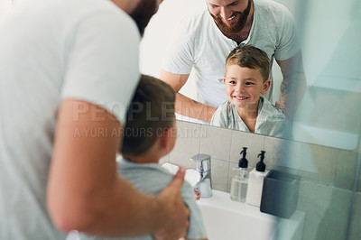 Buy stock photo Cropped shot of an unrecognizable father helping his adorable little boy wash his hands in the bathroom at home