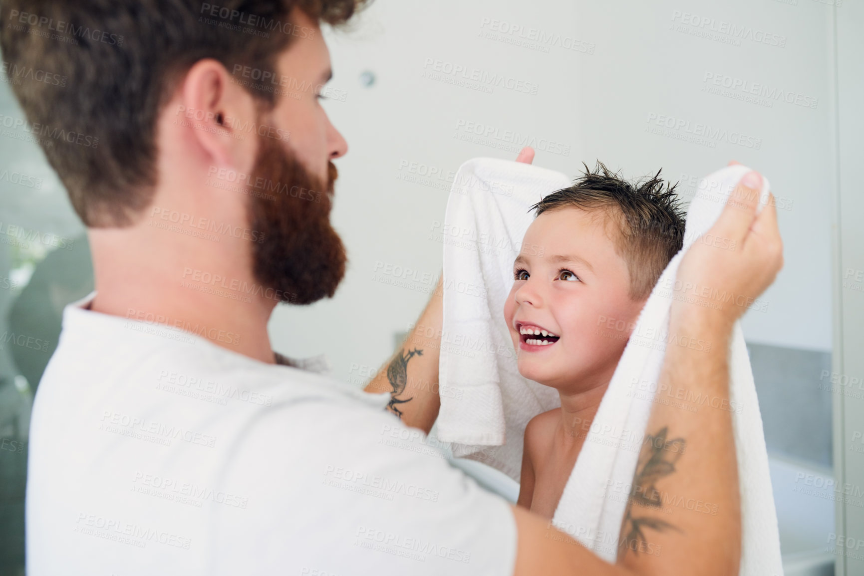 Buy stock photo Cropped shot of a young handsome father drying his adorable little son after a bath in the bathroom at home