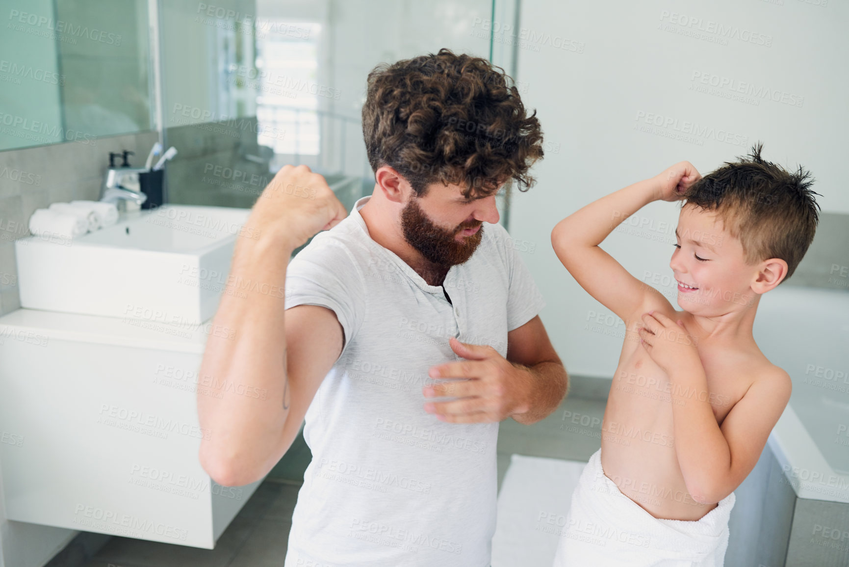 Buy stock photo Cropped shot of a young handsome father and his adorable little boy flexing their muscles together in the bathroom at home