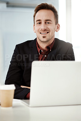 Buy stock photo Portrait of a young businessman working on a laptop in an office