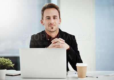 Buy stock photo Portrait of a young businessman working on a laptop in an office