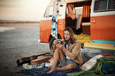 Buy stock photo Shot of a handsome young man taking a photo with his vintage camera on the beach