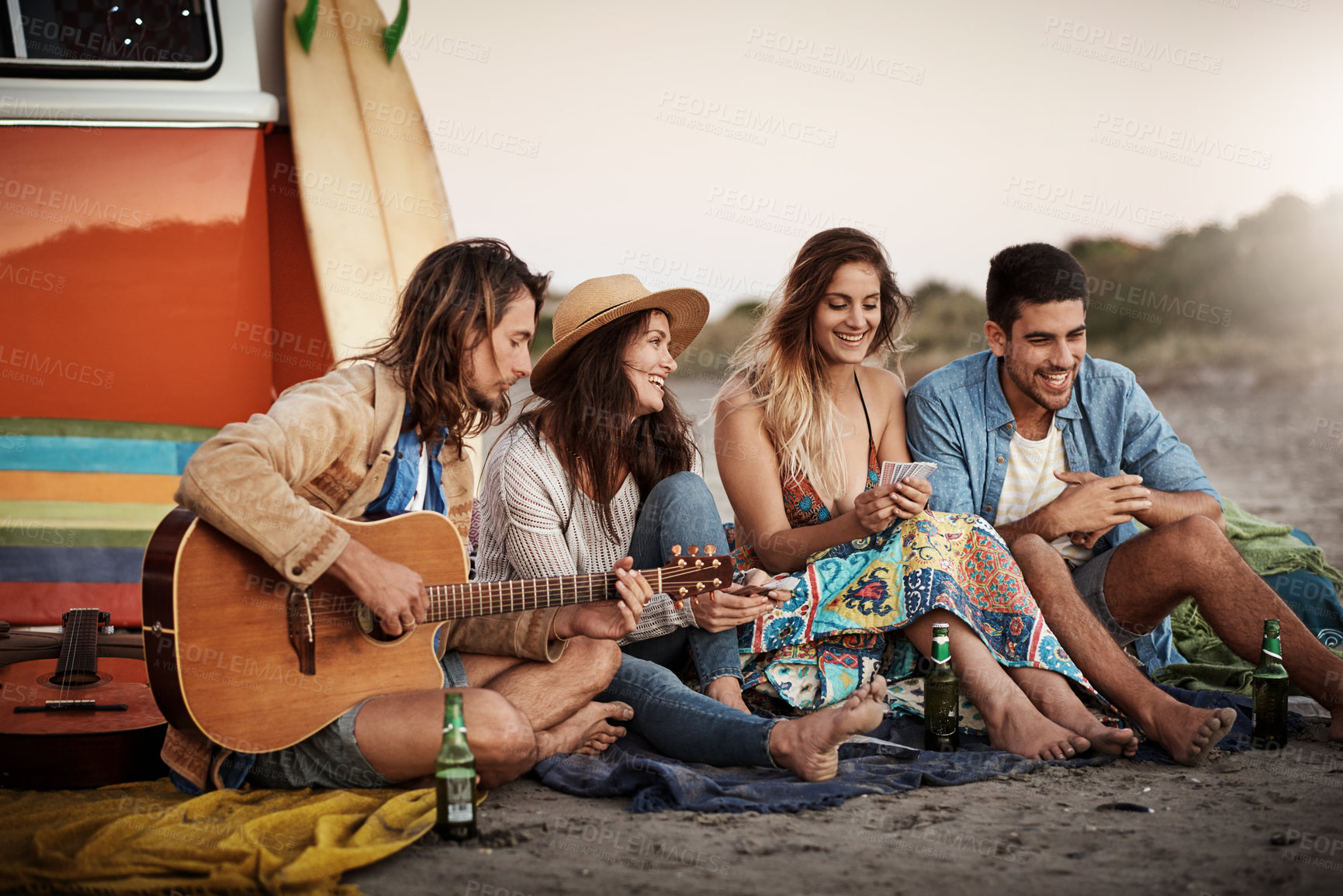 Buy stock photo Cropped shot of a group of friends hanging out together on the beach