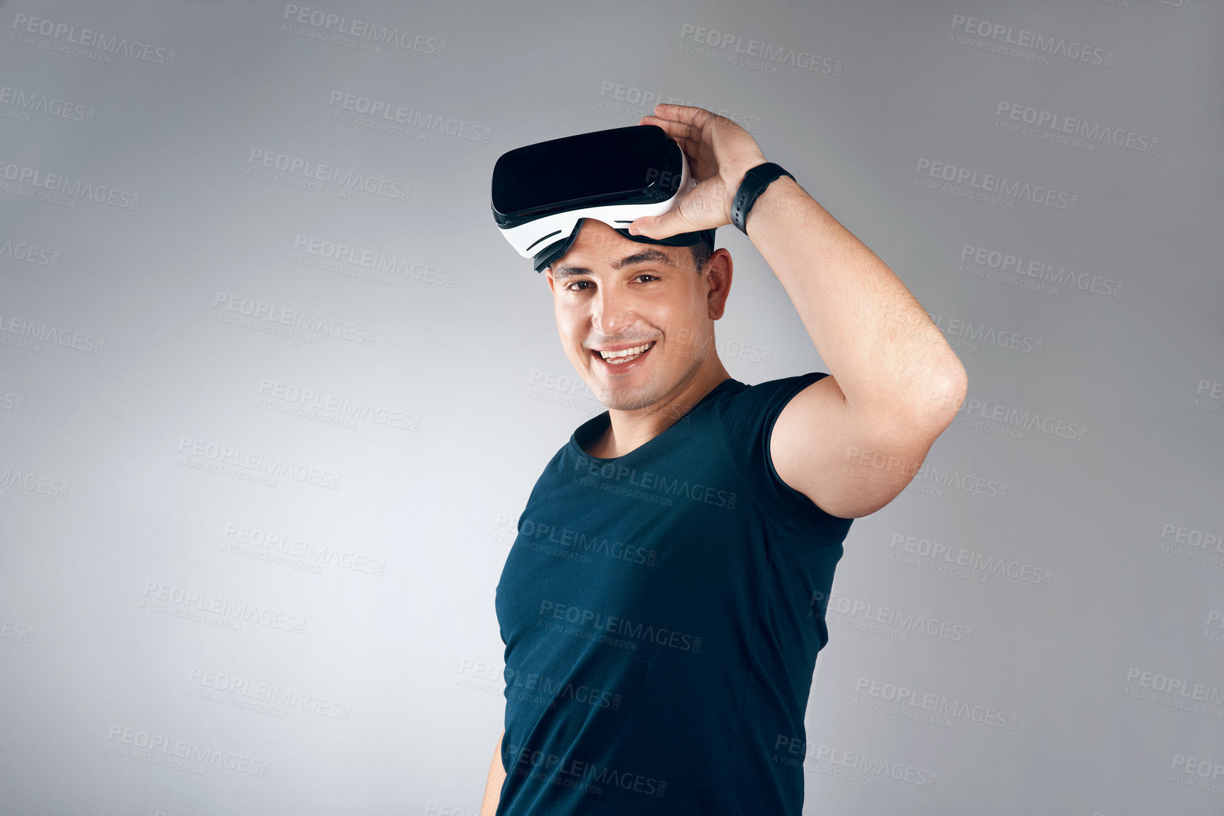 Buy stock photo Studio shot of a handsome young man posing with virtual reality goggles against a grey background