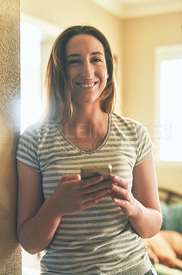 Buy stock photo Portrait of a young woman using a cellphone in the morning at home