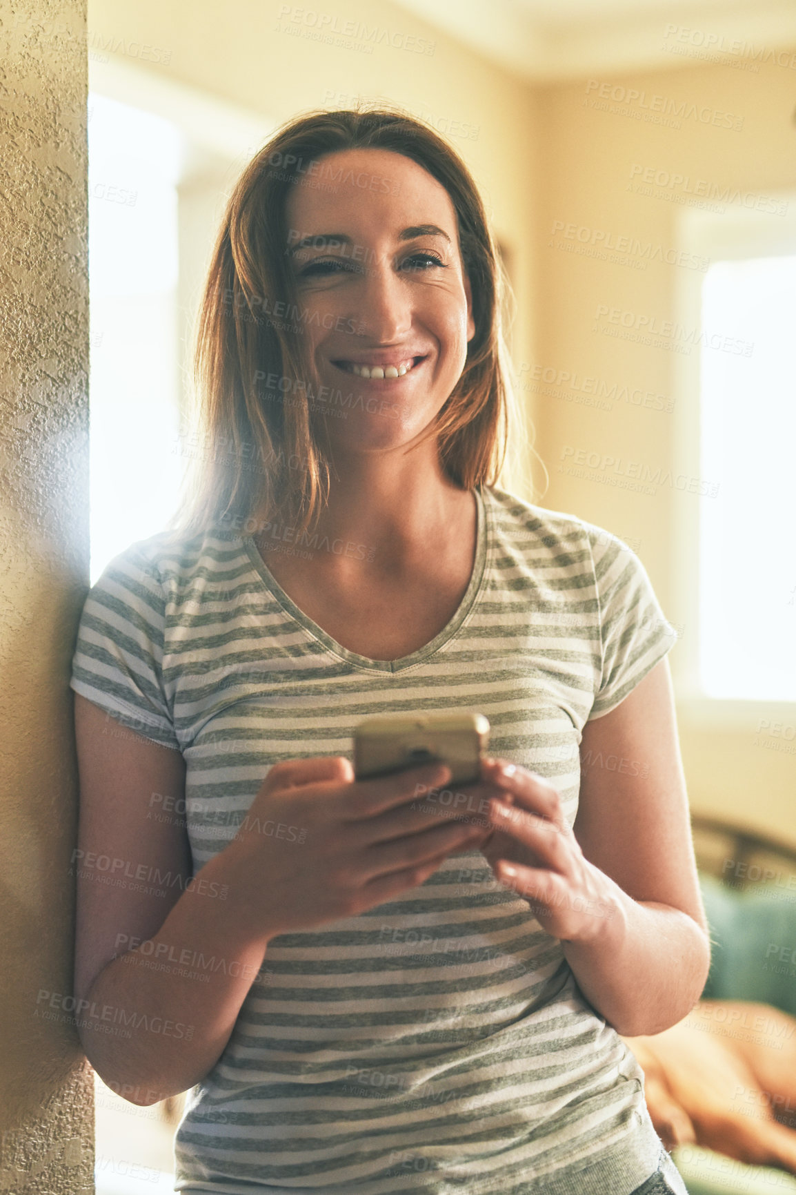 Buy stock photo Portrait of a young woman using a cellphone in the morning at home