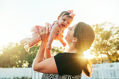 Buy stock photo Cropped shot of a mother kissing her adorable baby on the cheek in the backyard at home