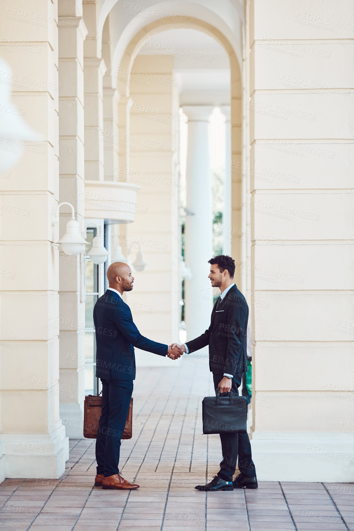 Buy stock photo Shot of two businessmen shaking hands in the city