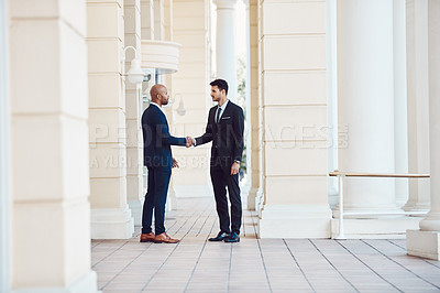 Buy stock photo Shot of two businessmen shaking hands in the city