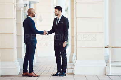 Buy stock photo Shot of two businessmen shaking hands in the city