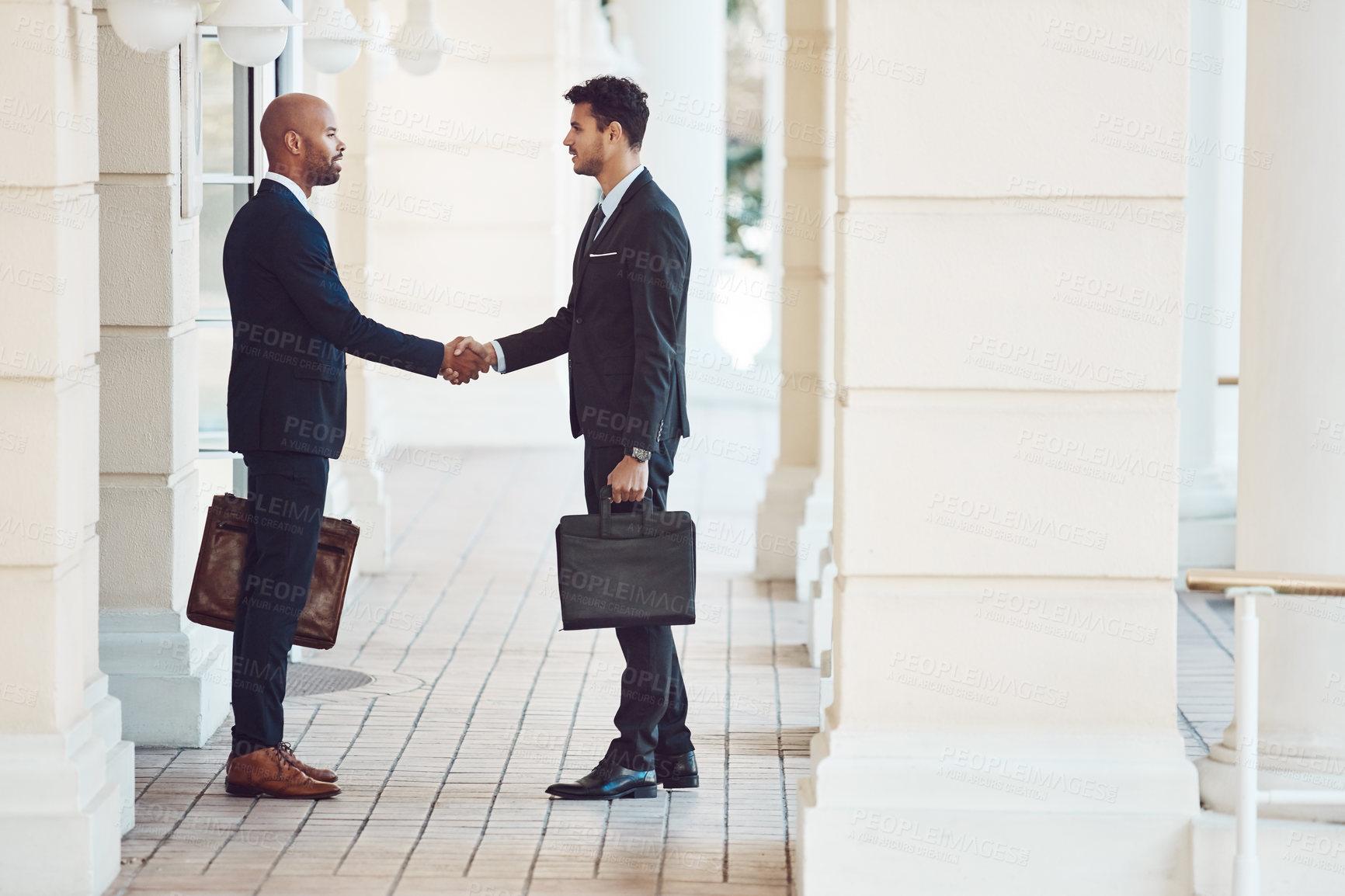 Buy stock photo Shot of two businessmen shaking hands in the city