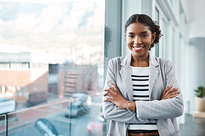 Buy stock photo Young, confident and ambitious business woman or corporate professional standing arms crossed by an office window in the city. Portrait of a happy female ready for success and looking positive