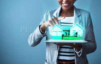 Buy stock photo Corporate business woman holding a tablet with property cgi graphics while standing against a blue studio background alone. Happy, smiling and cheerful female designing a vr home with technology