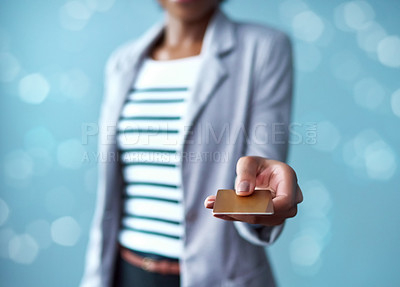 Buy stock photo Credit card in the hands of a finance business woman paying, buying and making a purchase while standing against a blue studio background alone. Corporate professional giving a debit card for payment