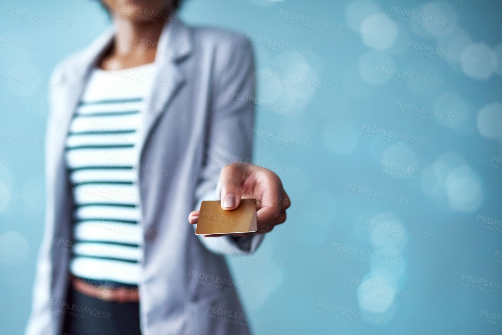 Buy stock photo Hand of woman holding credit card for banking, shopping and buying while standing alone isolated on blue copy space. Fingers of stylish african female paying for purchase on blue bokeh background