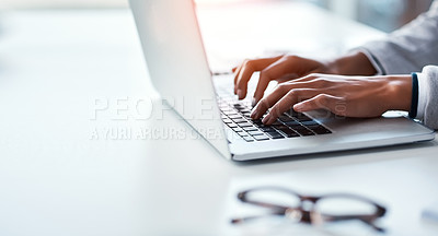 Buy stock photo Closeup of hands of a business person typing on a laptop, replying to emails and browsing the internet while sitting at a desk in an office alone at work. Employee searching online and doing research