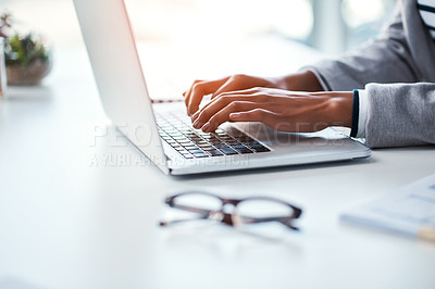 Buy stock photo Closeup of hands of a business person typing on a laptop, browsing the internet online and finishing a proposal while sitting at a table in an office at work. One employee networking on the web