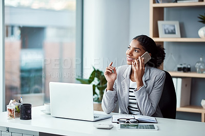 Buy stock photo Shot of a young businesswoman using a mobile phone at her desk in a modern office