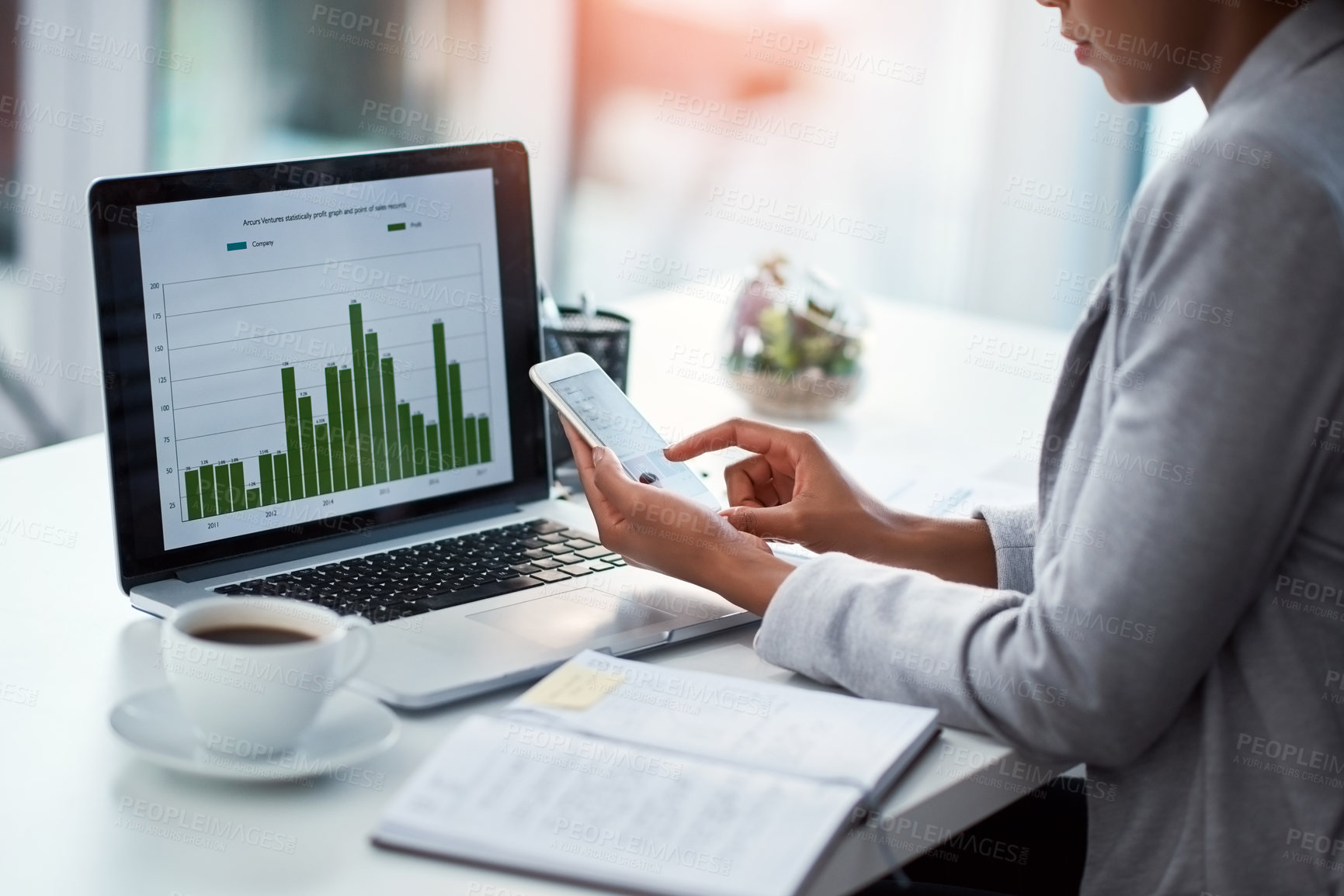 Buy stock photo Female data analyst or finance manager working on phone in a modern office. Business professional multitasking with graph and chart data on laptop, planning and analysis at the workplace.