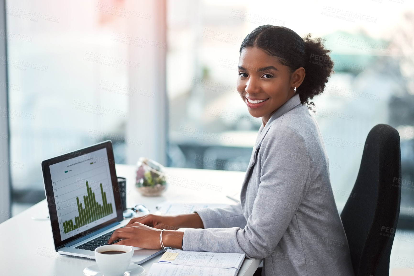 Buy stock photo Shot of a young businesswoman using a laptop with graphs on it in a modern office