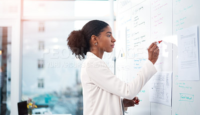 Buy stock photo Businesswoman planning marketing strategy on a whiteboard in modern office for a corporate company. Serious, focused and professional African female writing a smart and creative idea at the workplace