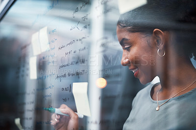 Buy stock photo Writing, planning strategy and brainstorming ideas on a glass wall in a modern design office. Young business woman thinking and drawing up a plan for success on a transparent board in the boardroom