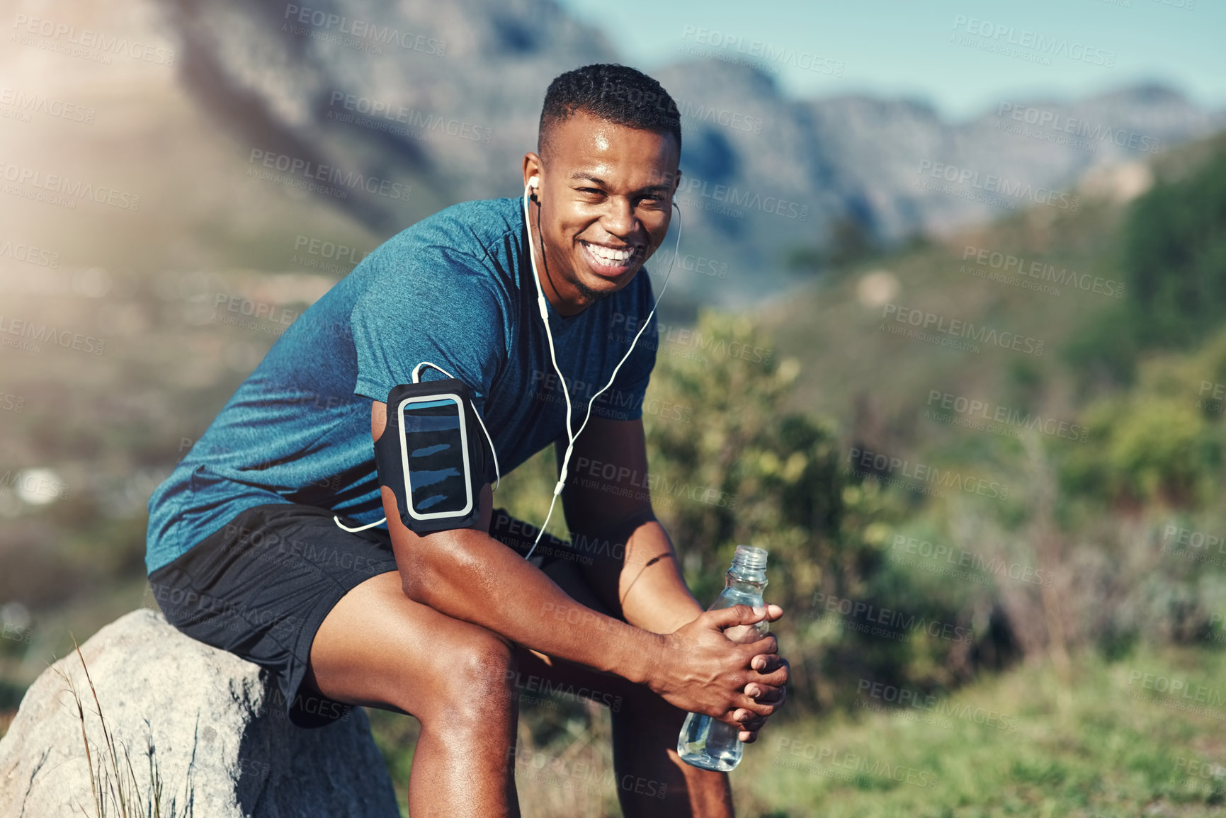 Buy stock photo Cropped shot of handsome young male runner taking a break and drinking water outdoors