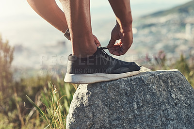 Buy stock photo Runner, foot and tying laces on rock, outdoors and prepare for cardio and marathon training. Man, stone and shoe for exercise or sports in nature, getting ready and sneaker for workout or athlete