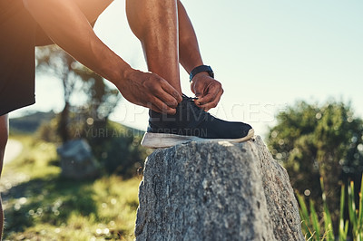 Buy stock photo Runner, legs and tie shoelaces on rock, outdoors and prepare for cardio and marathon training. Man, stone and shoe for exercise or sports in nature, getting ready and foot for workout or athlete