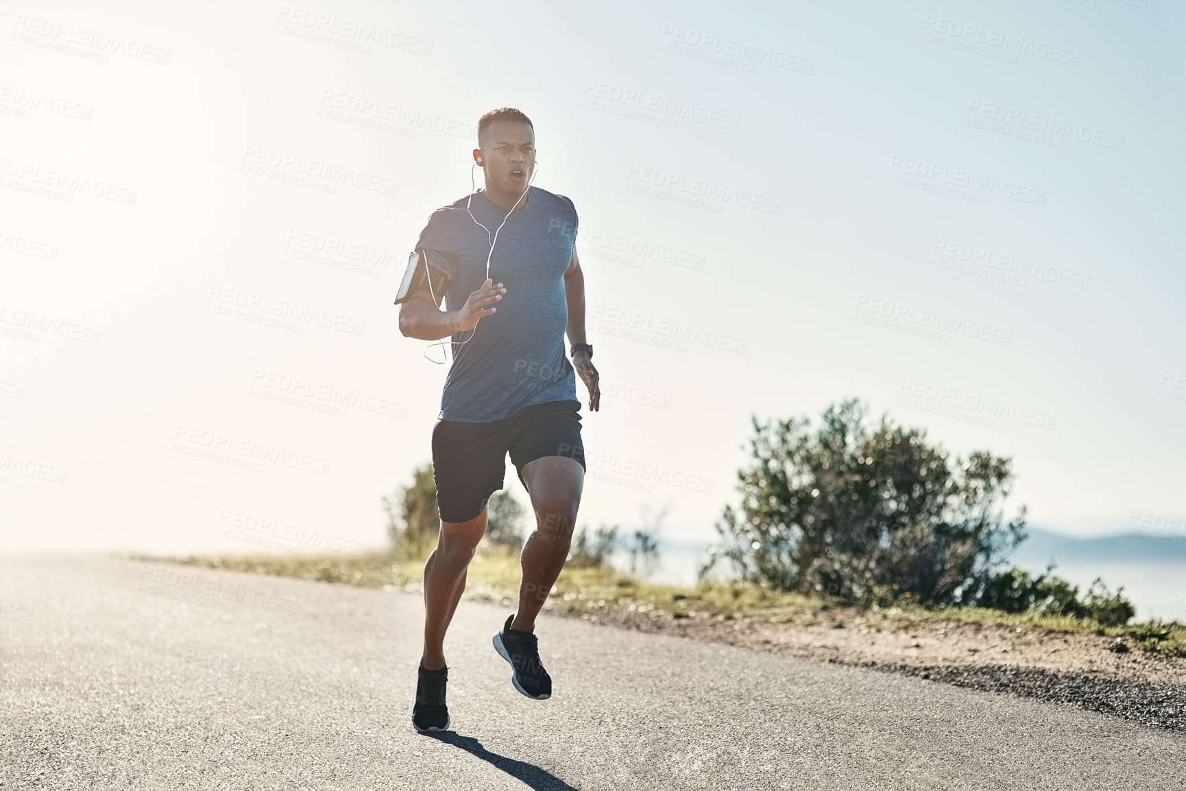 Buy stock photo Black man, running and road with fitness, exercise and motivation or training for future sports competition. Athlete, jog and outdoor for workout, health and performance with earphones or music