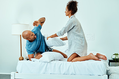 Buy stock photo Cropped shot of an affectionate young couple pillow fighting in their bedroom