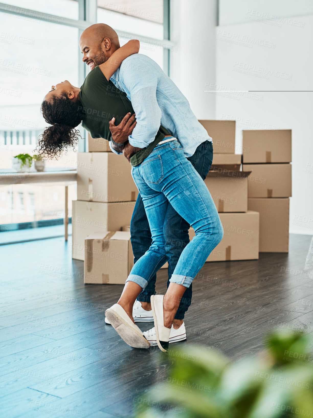 Buy stock photo Shot of a young couple celebrating the move into their new home