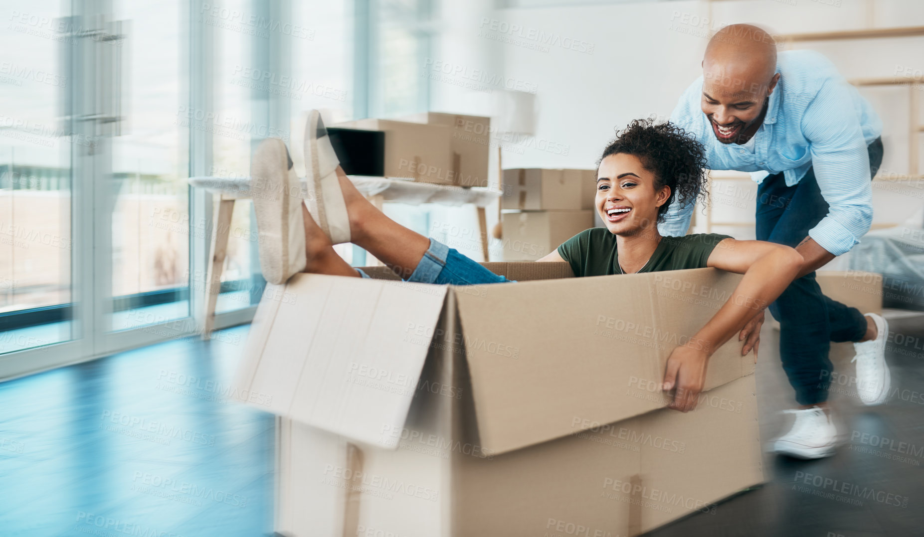 Buy stock photo Shot of a young couple having fun while moving house