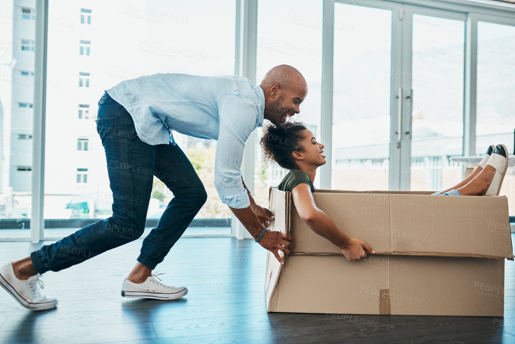Buy stock photo Shot of a young couple having fun while moving house
