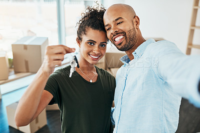 Buy stock photo Portrait of a young couple taking a selfie while holding the keys to their new home