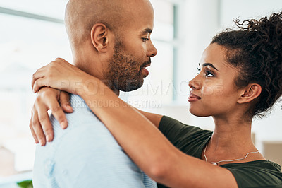 Buy stock photo Shot of a young couple hugging each other while moving house