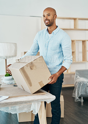 Buy stock photo Shot of a young man carrying a box while moving house