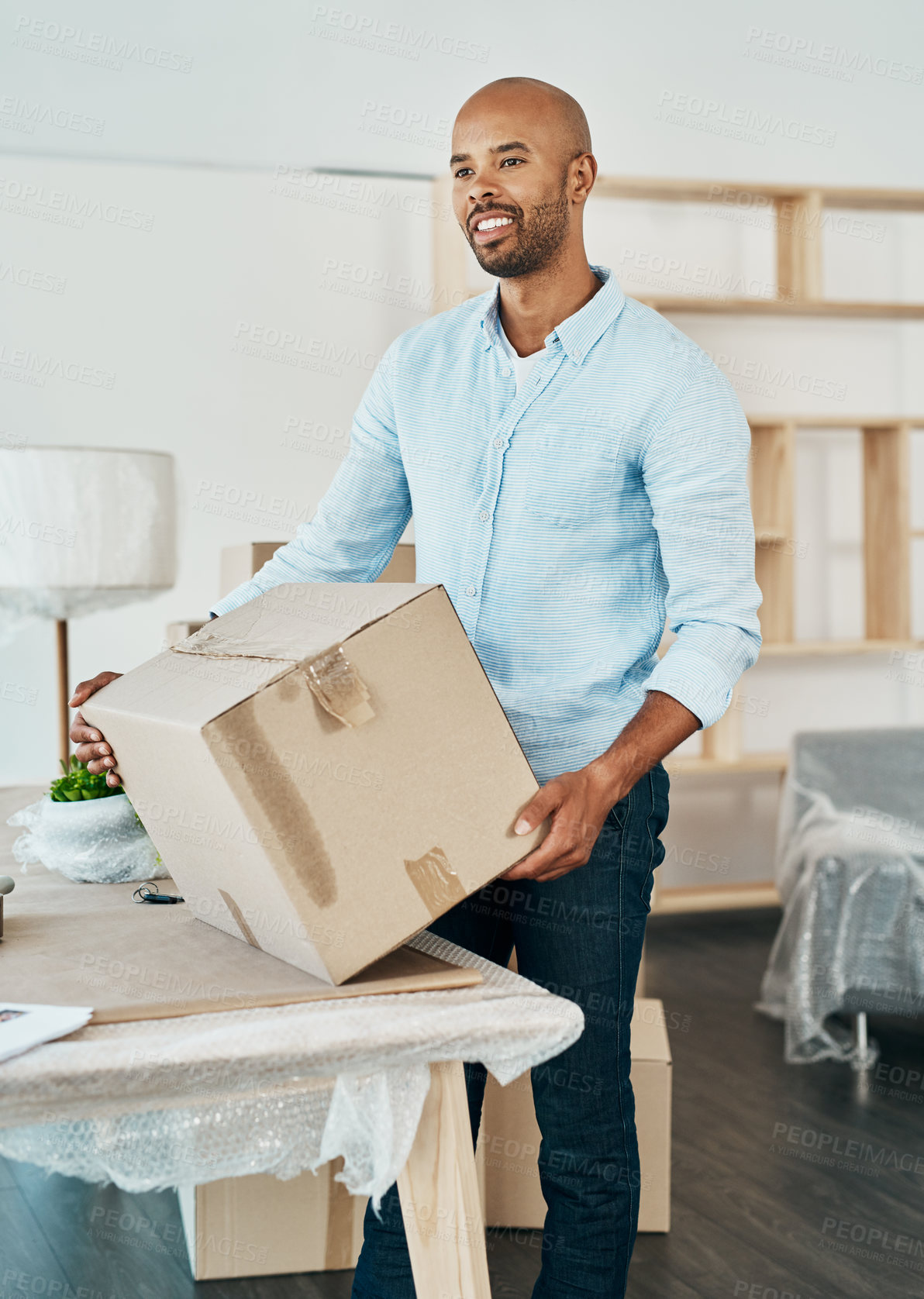 Buy stock photo Shot of a young man carrying a box while moving house