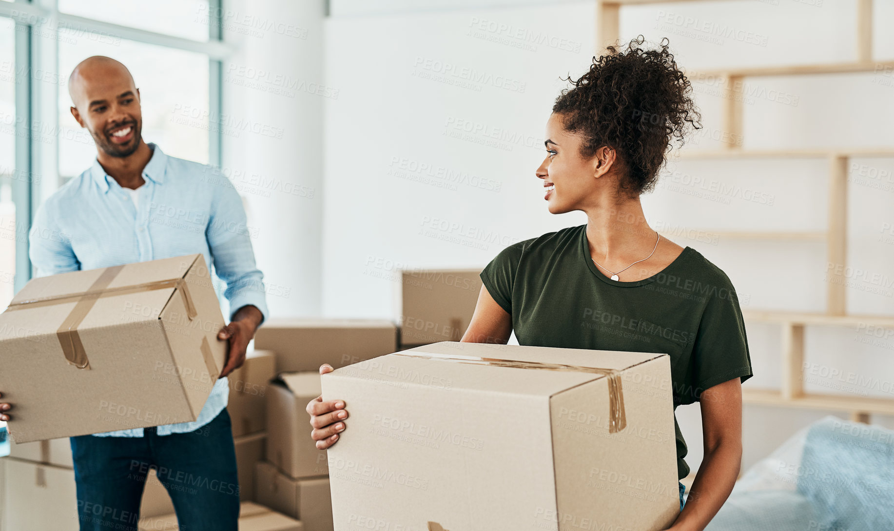Buy stock photo Shot of a couple young carrying boxes while moving house